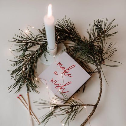 Maxi-Streichhölzer von Eulenschnitt mit Schriftzug make a wish auf der Rückseite, weihnachtliches Moodbild mit brennender Kerze auf einem Tisch